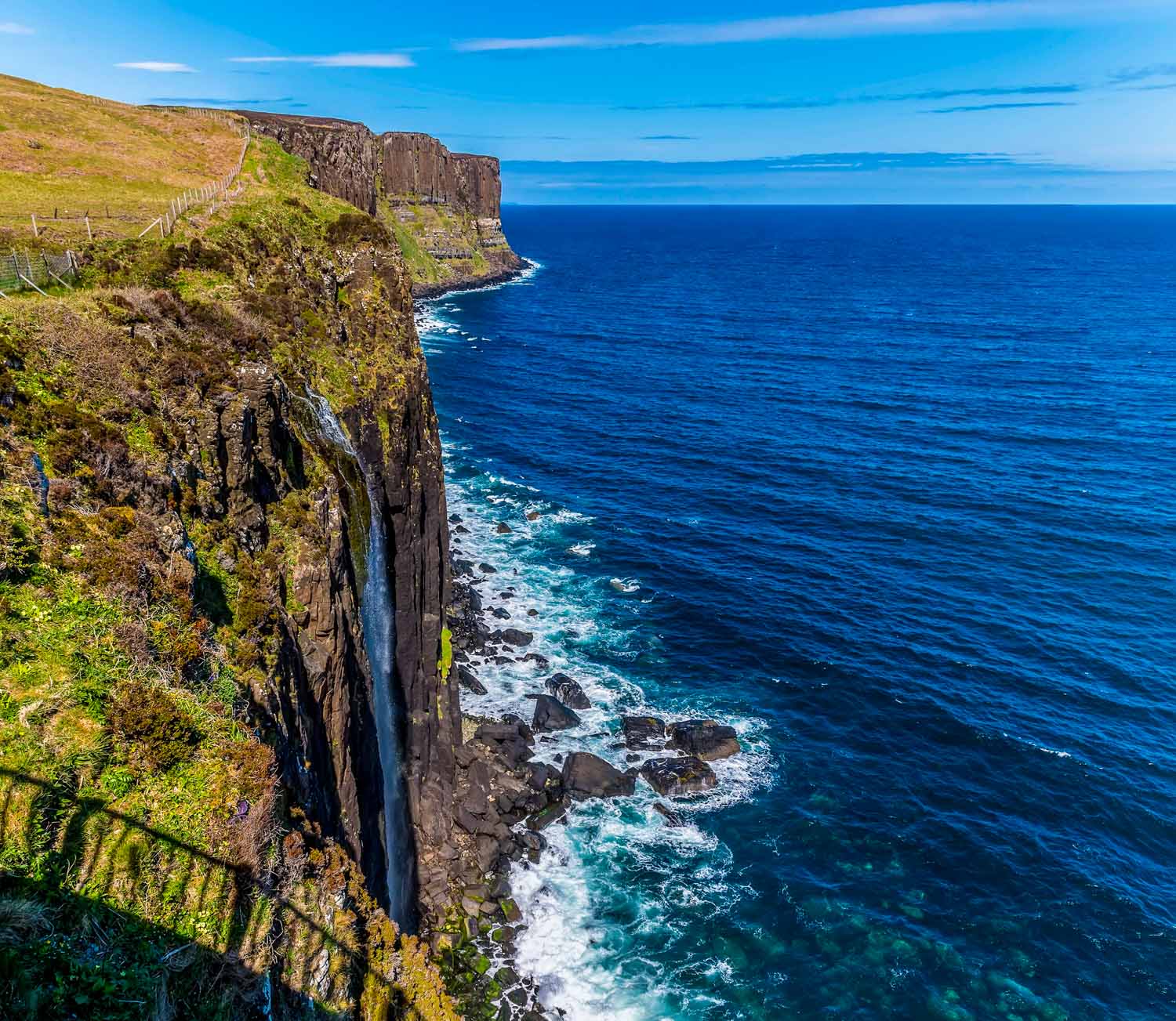 View of the Mealt Falls and Kilt Rock on a sunny day - one of the best places to visit on Skye with kids