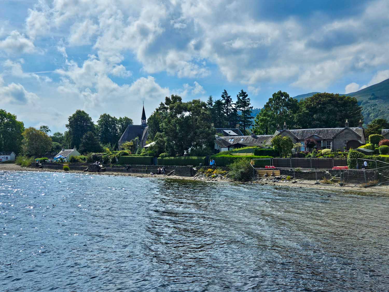View of some of the buildings, church and beachfront at Luss - my pick of the best things to do in Loch Lomond with kids