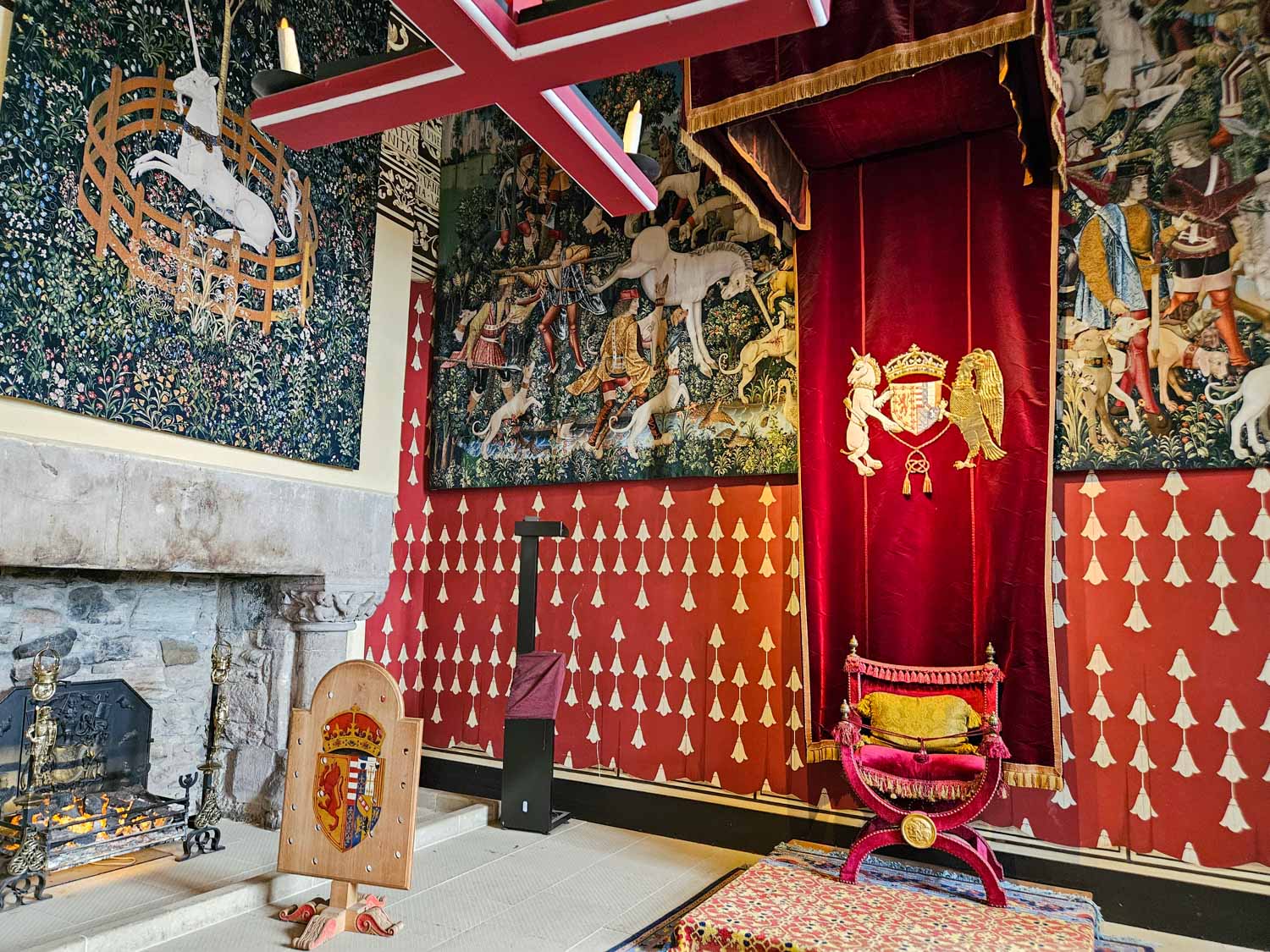 Velvet chair under a canopy of state and ornate tapestries depicting unicorns in the palace royal apartments at Stirling Castle - a visit is one of the best things to do in Stirling with kids