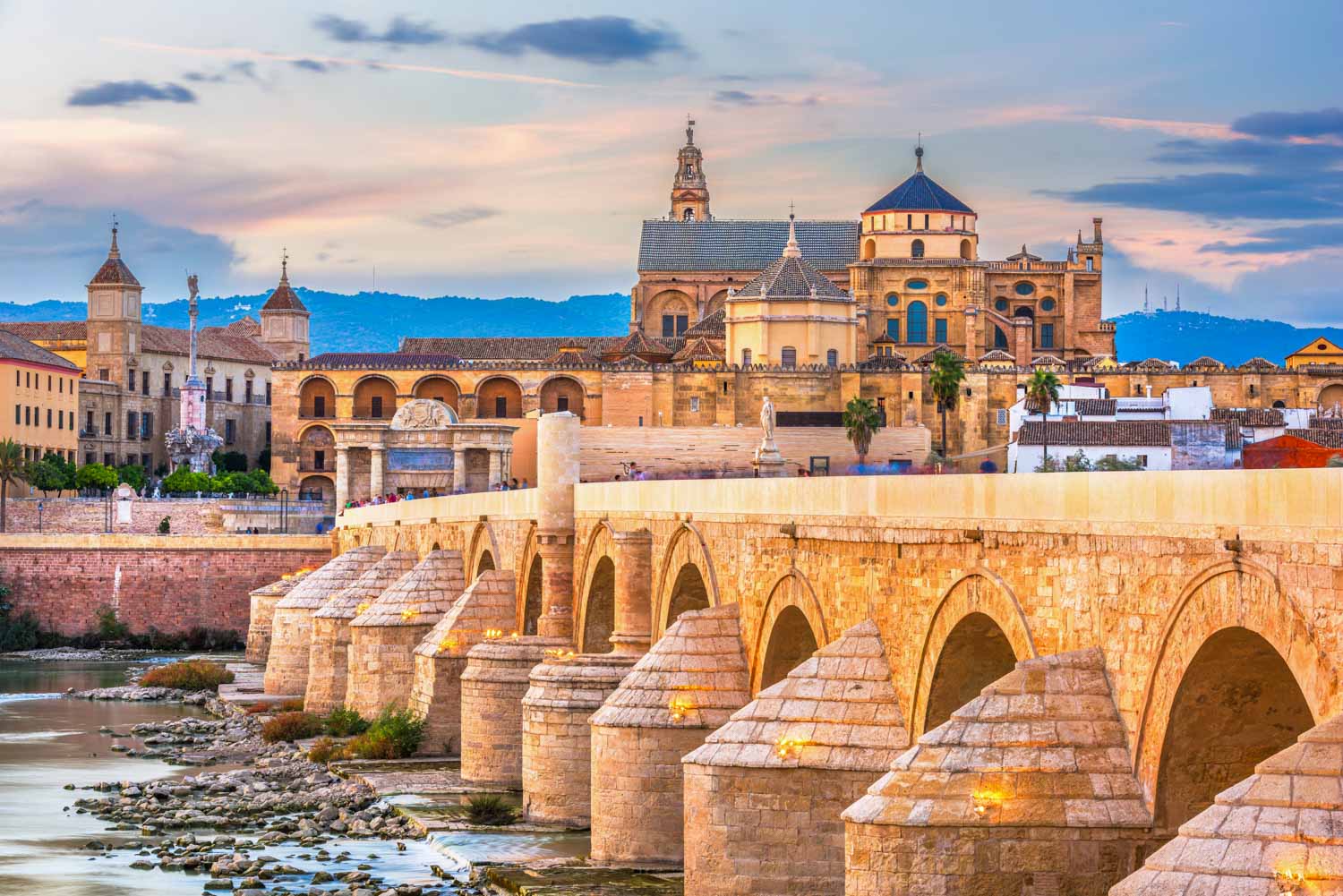 View across the Roman bridge to the Mezquita cathedral-mosque in Cordoba - one of the best day trips from Malaga with kids
