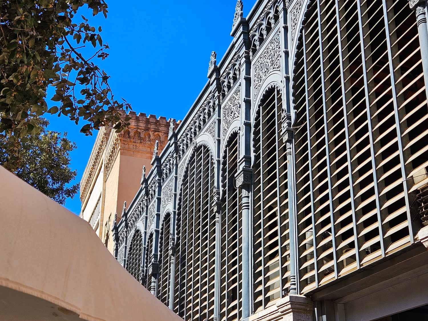 View of the decorative ironwork and part of the original Nasrid arch at Atarazanas market in Malaga - one of the best places to visit in Malaga with kids