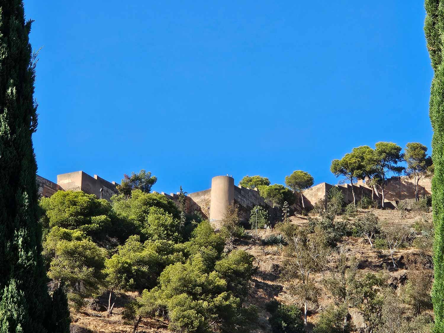 View up to the towers and walls of Gibralfaro Castle in Malaga - a visit is one of the best things to do in Malaga with kids