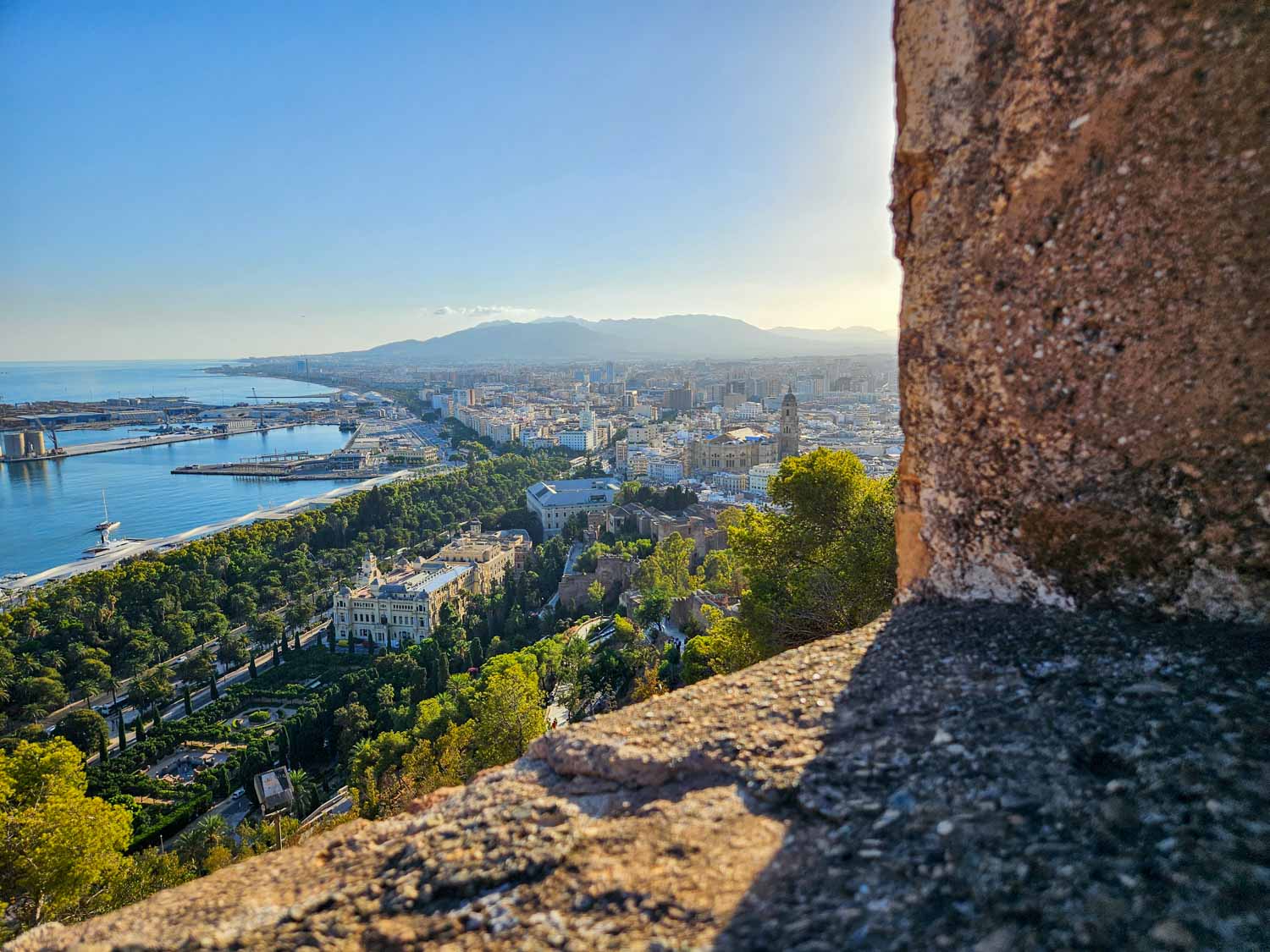 View from the castle ramparts down onto the buildings and park of Malaga - a visit is one of the best things to do in Malaga with kids