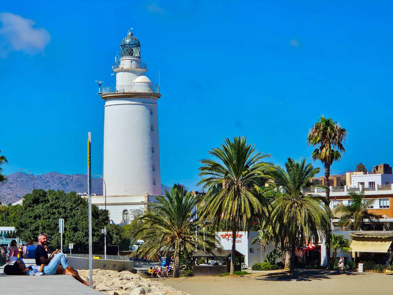 White lighthouse at the end of La Malagueta beach - the closest beach to the city if you're visiting Malaga with kids