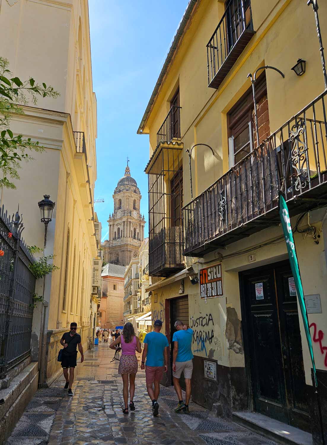 View down a narrow cobbled street in Malaga's old town to the cathedral - a walking tour is one of the best things to do in Malaga with kids