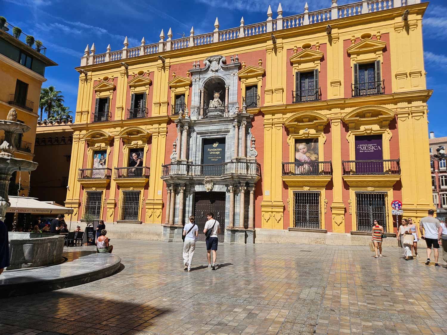 The deep yellow and ochre red facade of the Cultural Centre in the old town of Malaga - a walking tour is one of the best things to do in Malaga with kids