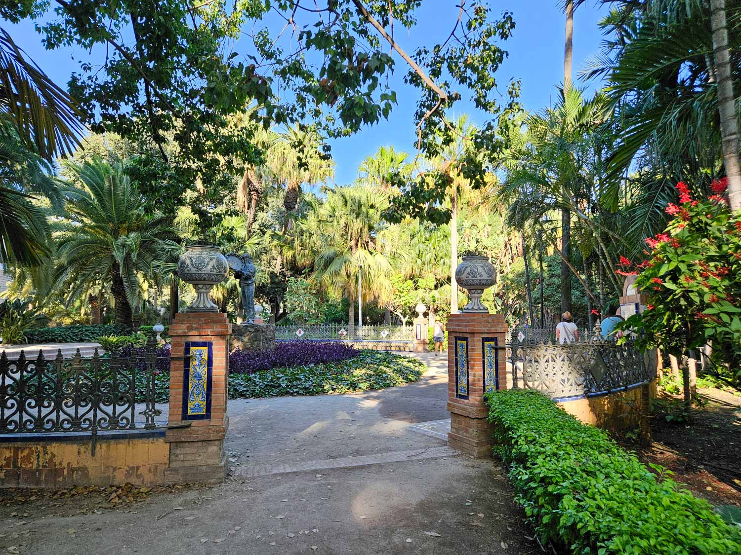 Decorative tiled gate in Paseo del Parque, shaded by palm trees - a visit is one of the best things to do in Malaga with kids