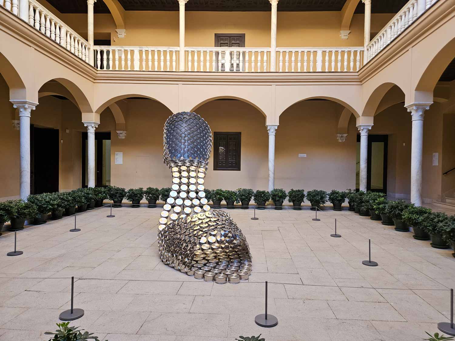View of a shoe sculpture made of pans, part of a temporary exhibition in the courtyard of the building housing the Picasso Museum in Malaga - the best place to visit in Malaga with kids who love art