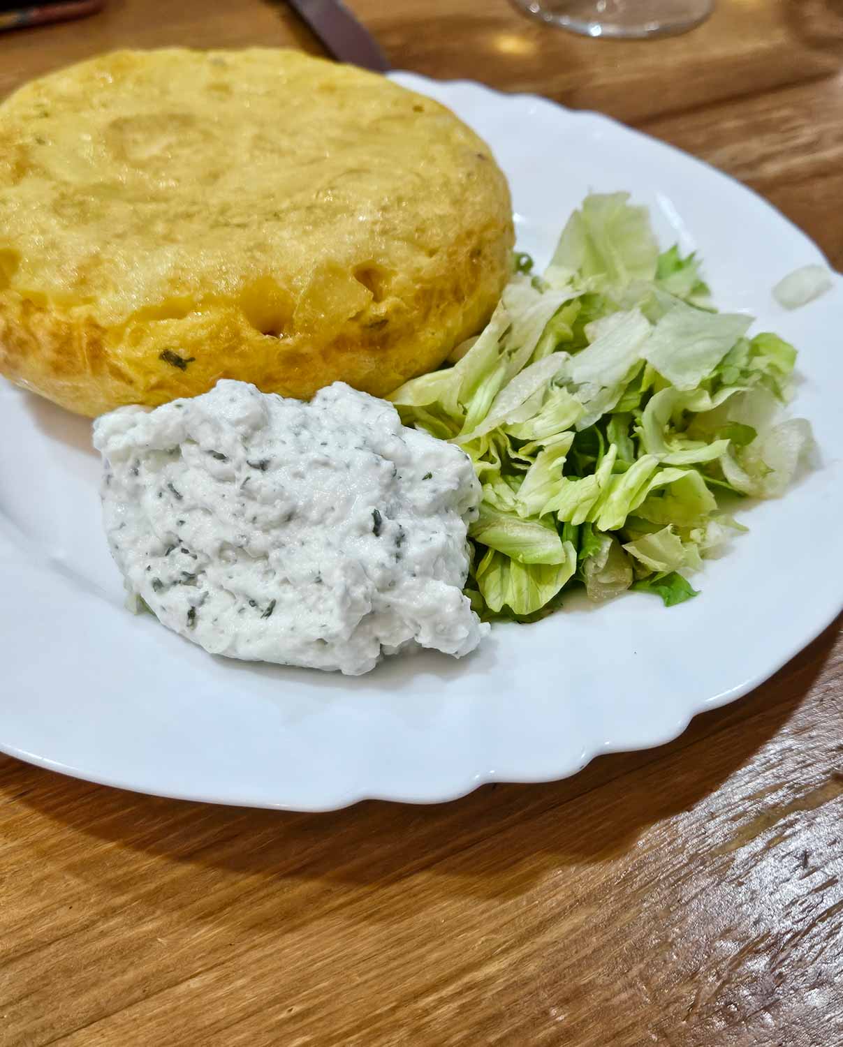 Plate with tortilla (spanish omelette) with sauce and salad leaves - a tapas tour is one of the best things to do in Malaga with teens